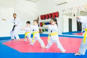 Kids Taekwondo class practicing basic punches in a bright martial arts studio
